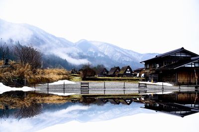 Scenic view of lake and snowcapped mountains against sky