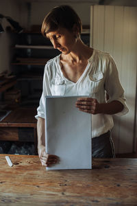 Woman handling stack of paper sheets, handmade book production process