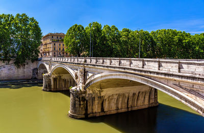 Arch bridge over river against sky