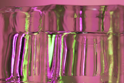 Abstract close up fluted glass object in pink and green. 