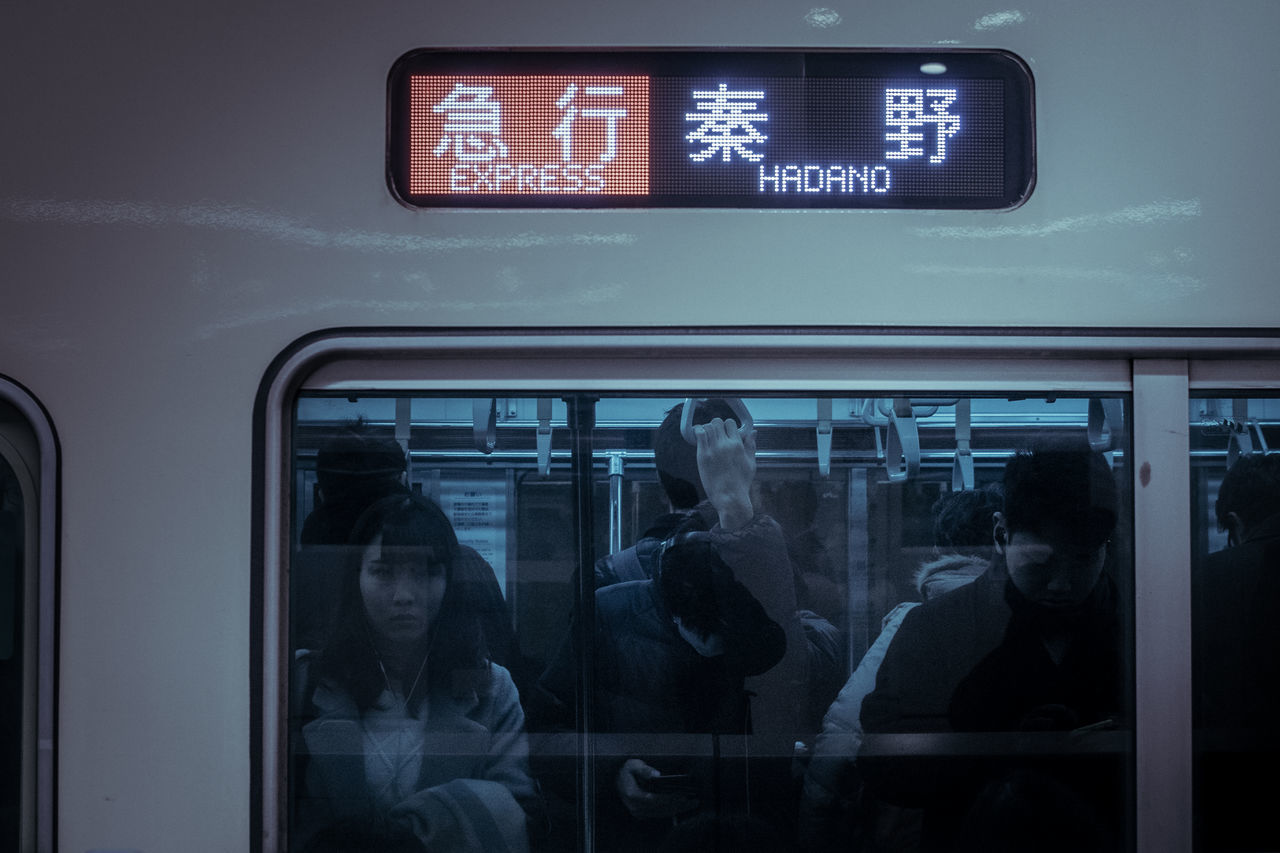 communication, transportation, text, public transportation, mode of transport, train - vehicle, journey, real people, illuminated, land vehicle, indoors, time, technology, women, day, young adult, adult, people