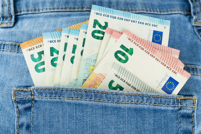 Close-up of paper currencies in jeans pocket