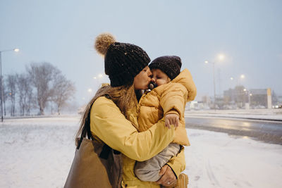 Rear view of couple standing in snow during winter