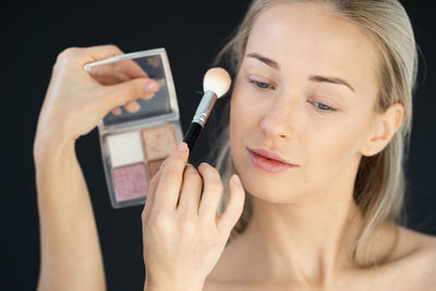 Close-up portrait of woman holding smart phone