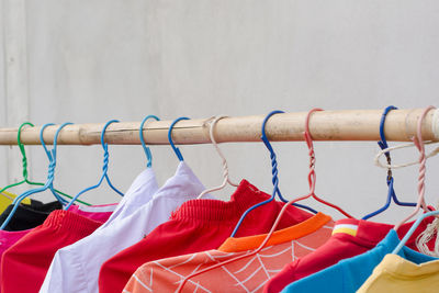 Close-up of multi colored umbrellas hanging on rack against wall