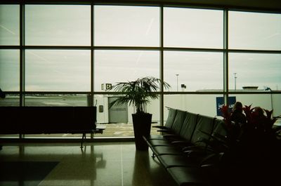 Chairs and tables in glass window at airport