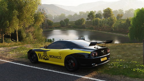 Car by lake against mountains