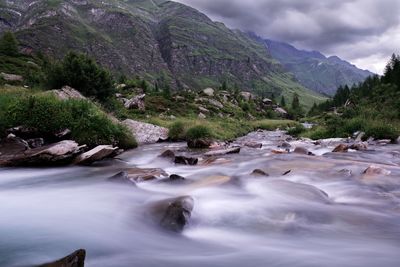 Scenic view of river amidst mountains against sky