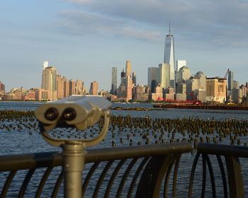 Close-up of coin-operated binoculars with buildings in backgrounds