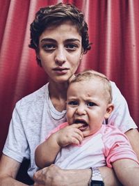 Portrait of mother and baby sitting at home