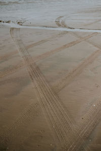 High angle view of tire tracks at beach