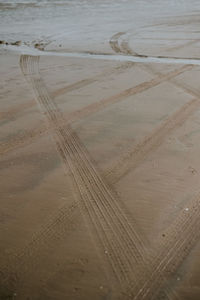 High angle view of tire tracks on beach