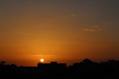 Silhouette cityscape against sky during sunset