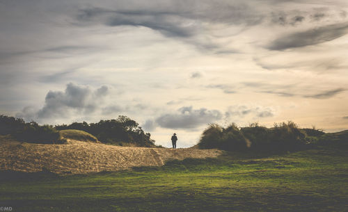 Scenic view of field against cloudy sky