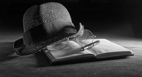 Close-up of hat with book on table