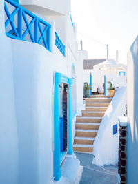 Staircase by building against blue sky