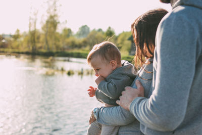 Midsection of family by lake