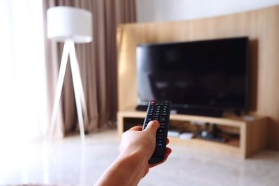 Close-up of hand holding camera at home