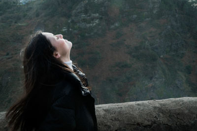 Side view of woman looking at camera