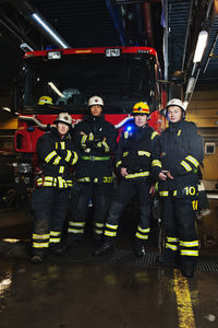 Portrait of fire fighters in front of fire engine