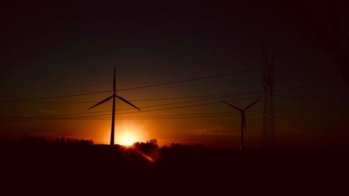 Silhouette electricity pylon against sky during sunset