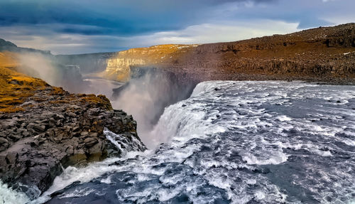 Scenic view of waterfall against sky