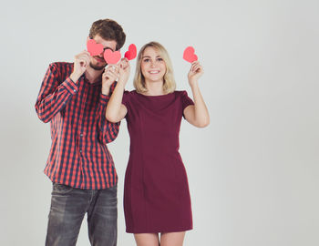 Young couple standing against white background