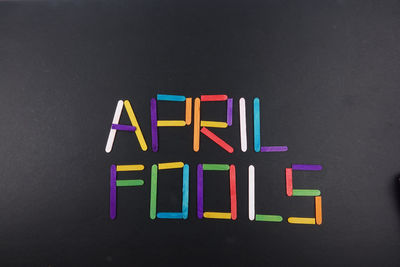 Directly above shot of colorful april fools text on black table