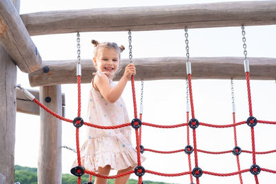 Low angle view of boy swinging at playground