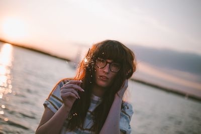 Portrait of young woman against sky during sunset