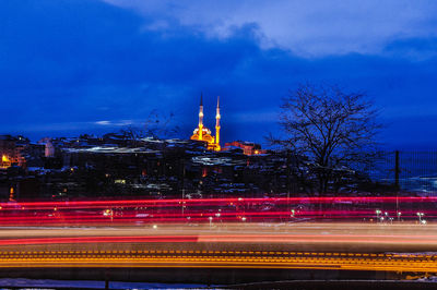 Light trails on street against sky at night