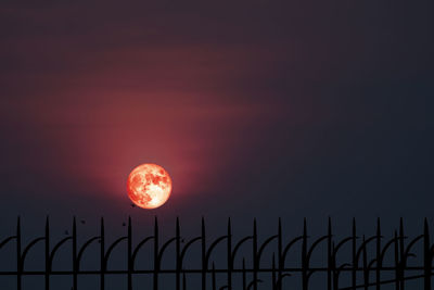 Low angle view of silhouette fence against sky during sunset