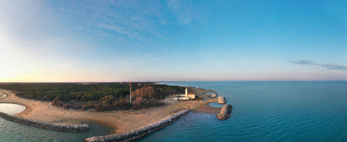 Bibione lighthouse from above at sunset in a panoramic aerial view	with sea and blue sky