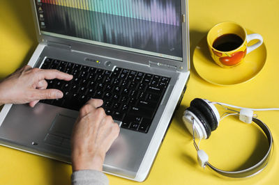 Midsection of man using laptop on table