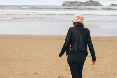 Rear view of woman standing on beach