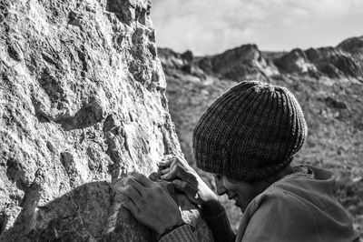 Side view of woman climbing on rock