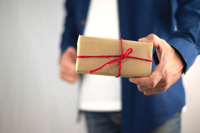 Midsection of man holding paper in box