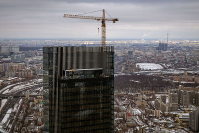 Aerial view of crane and buildings against sky