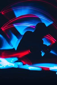 Silhouette person dancing in illuminated nightclub