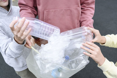 Hands of man and children collecting plastic garbage