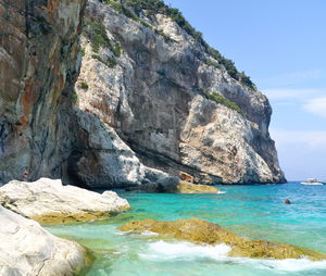 Scenic view of rocks on sea against sky