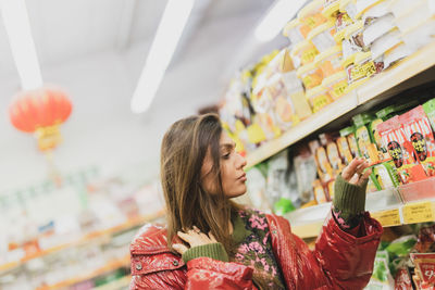 Woman looking at product while standing at store