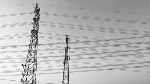 Low angle view of electricity pylon against clear sky