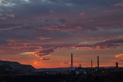 Silhouette buildings against sky during sunrise 