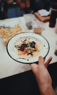 High angle view of hand holding food in plate
