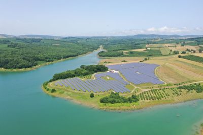 Aerial view of river amidst field against sky