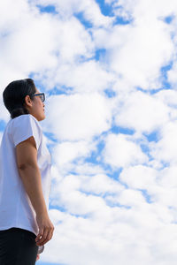 Low angle view of woman standing against sky