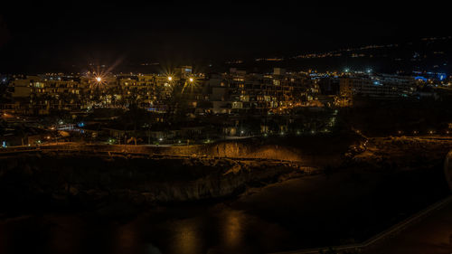 High angle view of illuminated buildings in city at night