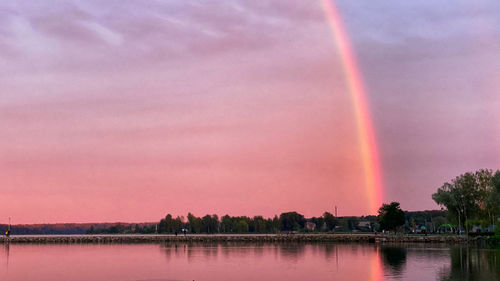 Scenic view of rainbow over lake against sky