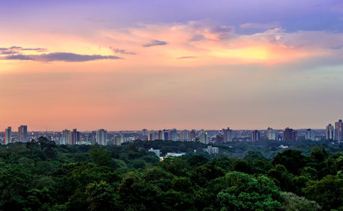 View of trees and buildings against sky during sunset